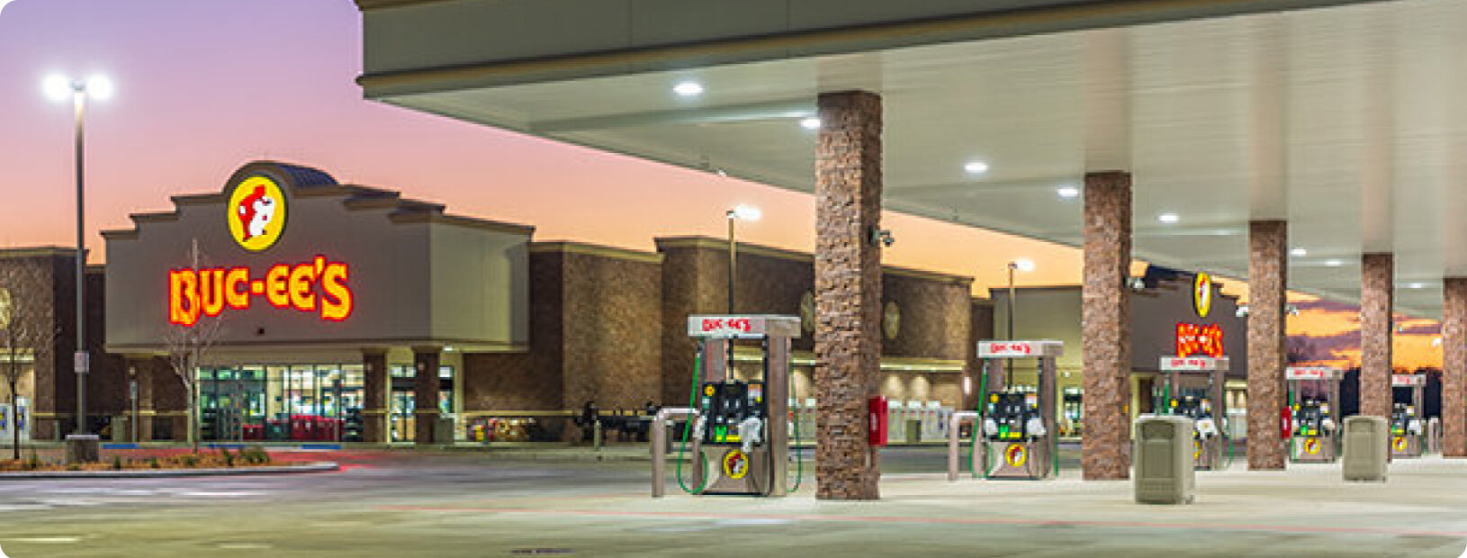 Wide-angle photo of Buc-ee's convenience store & gas station location with fuel pumps in foreground