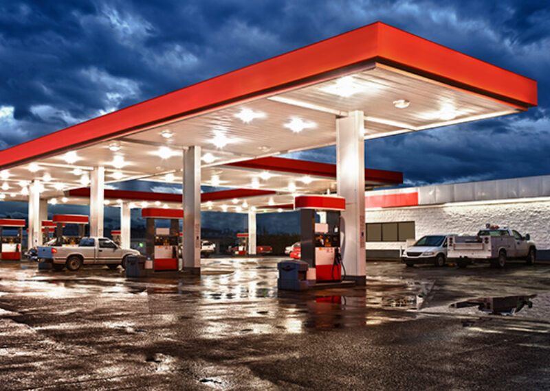 Night view of a red gas station with pumps