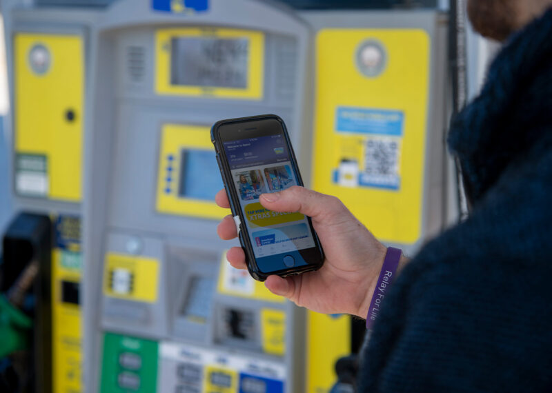 Man using a gas station app at fuel pump