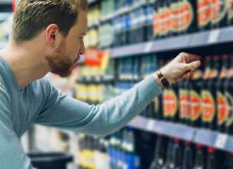 Man selecting a bottle of alcohol from a shelf