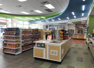 green and blue interior of convenience store with food aisles