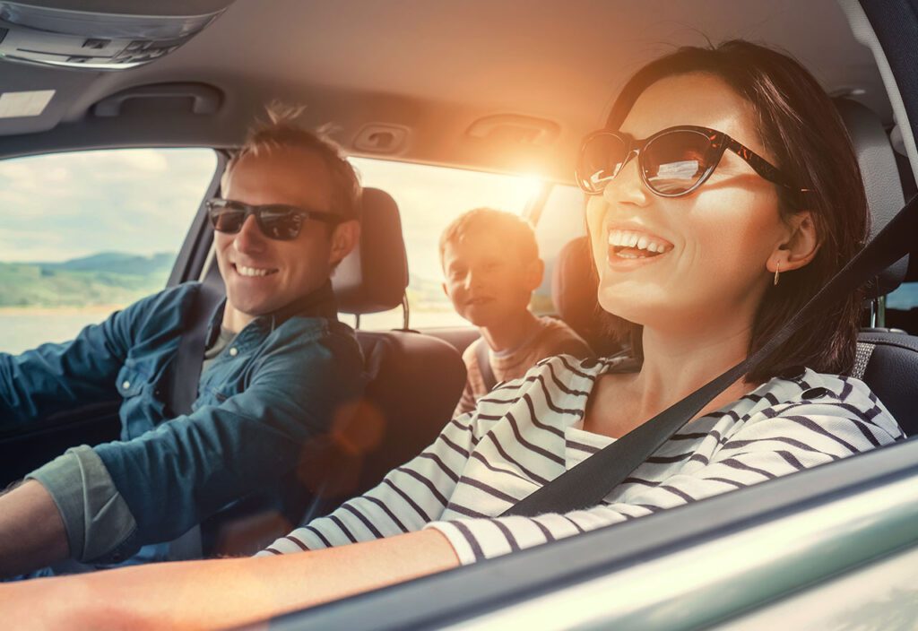 Happy family of three riding in their car together.