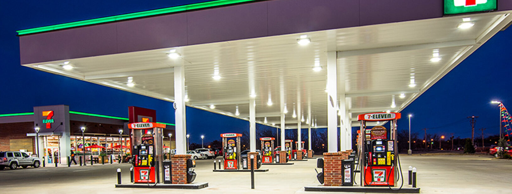 Wide-angle view of 7-Eleven gas station and c-store with fuel pumps in foreground