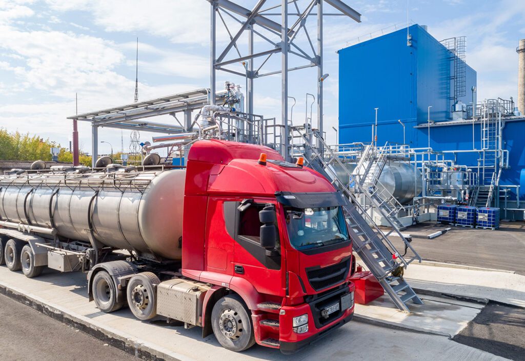 Petroleum being fueled into large tanker at factory.