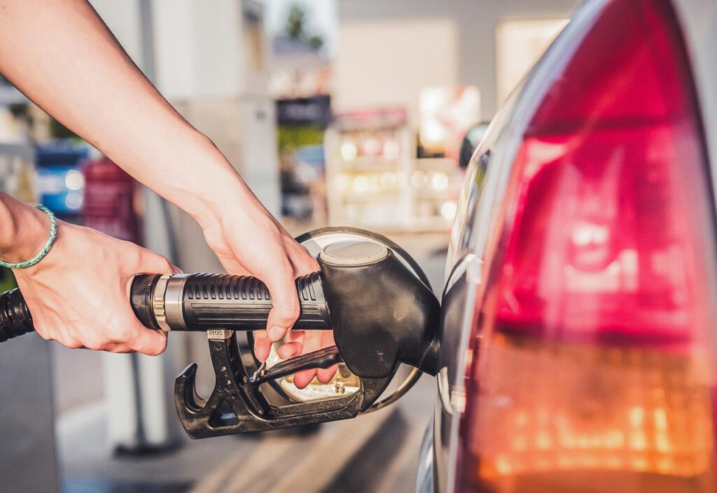 Woman pumping petrol with fuel pump at gas station