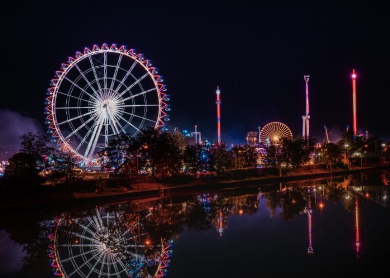 A city skyline at night with a ferris wheel