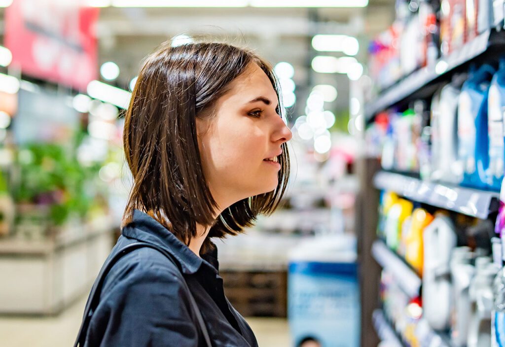 Female shopper looking at products in consumer packaged goods store.