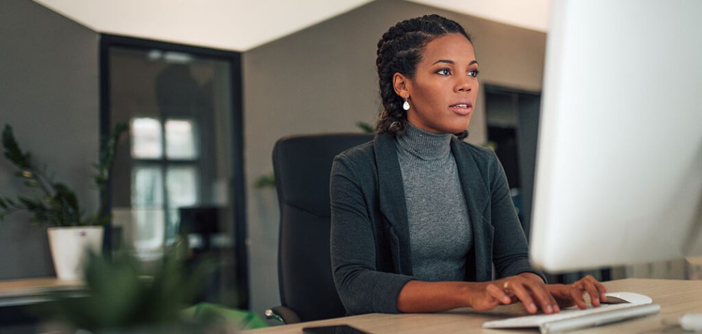 Female entrepreneur using laptop to work on back office tasks from office.