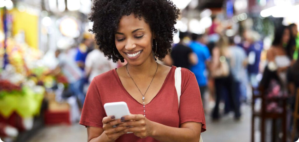 Woman smiling while in retail shop looking at her cell phone.