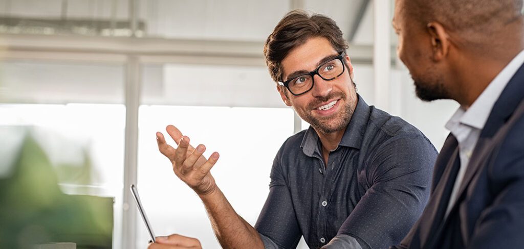 Two business men having a productive discussion while smiling.