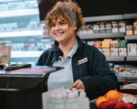 Smiling female cashier at gas station c-store