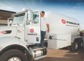 Driver standing by Pinnacle Propane truck