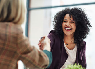 Handshake with a happy, confident and excited human resources manager and a female job candidate.