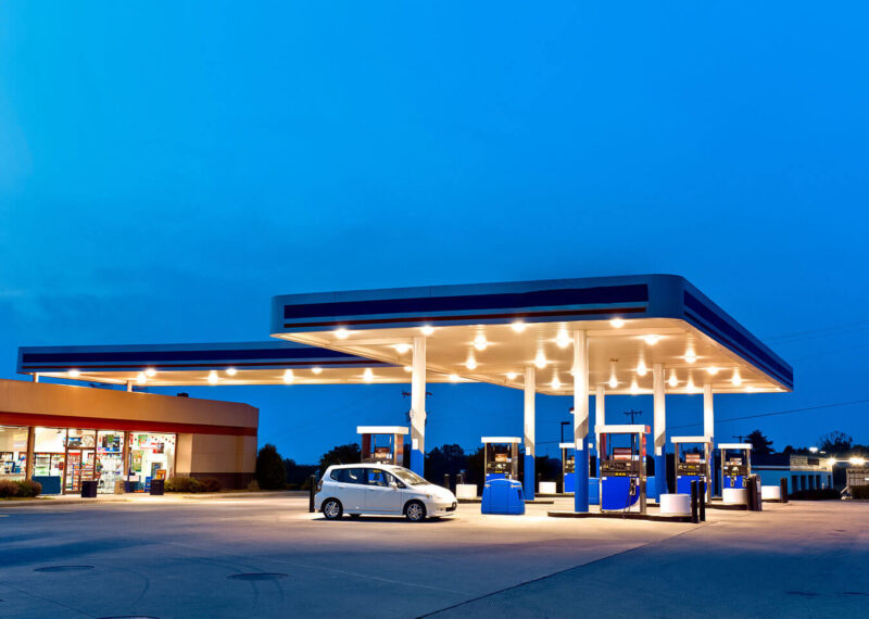 Gas station and convenience store at twilight with one care in forecourt