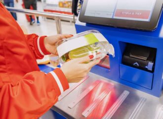 customer scans their own items at the self-service checkout in a convenience store