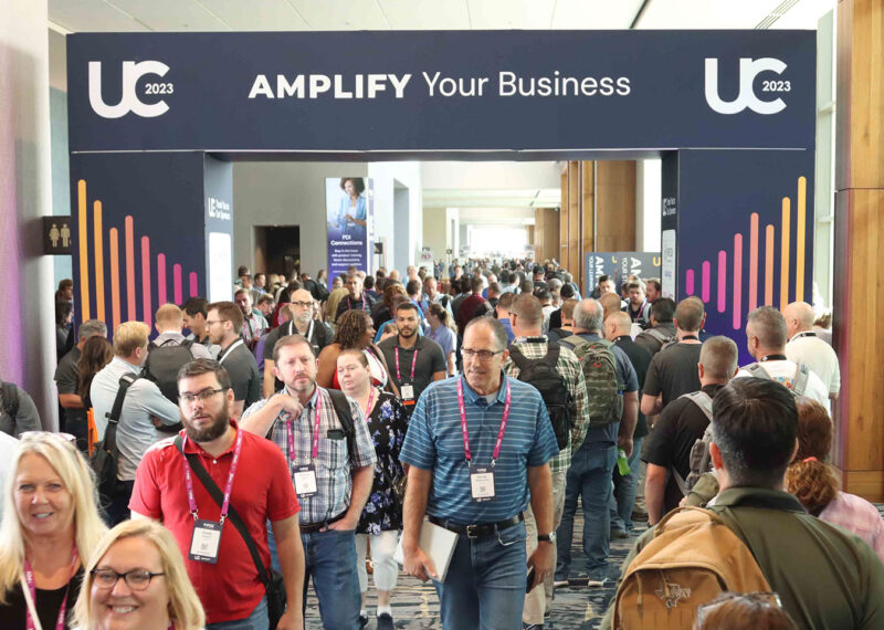 UC23 attendees walking under an Amplify Your Business sign at PDI's Users Conference 2023