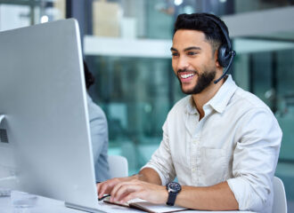 Business man, call center and web support communication at a computer in a office. Phone conversation, smile and male worker with contact us, crm and customer service job