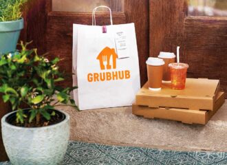 Grubhub bag on bench next to cardboard food boxes and drinks, food delivery loyalty