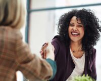 Supervisor and employee shaking hands after job review