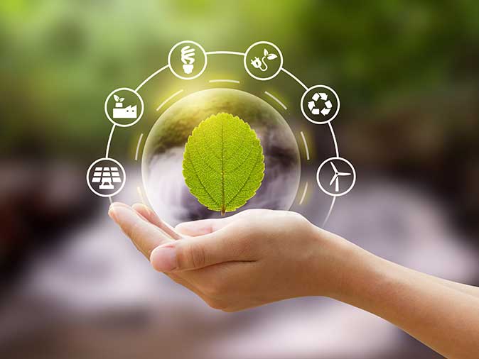 Eco friendly icon with a hand holding leaf in the bubble at green nature background