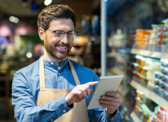Convenience store employee using tablet technology to manage staffing and training, representing modern workforce solutions from PDI’s C-Store Workforce Guide.