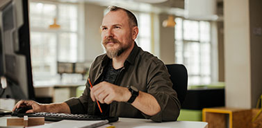 Middle aged man using a computer at a office job 