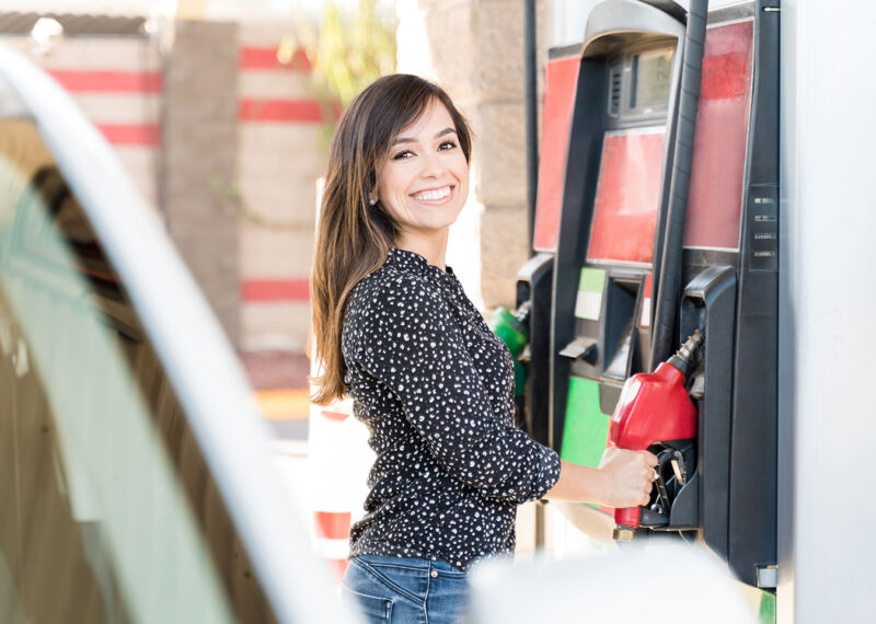 Young woman at gas station fuel pump
