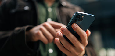 Close-up hands of unrecognizable man holding and using smartphone, browsing internet, using mobile application. Concept of modern communication.