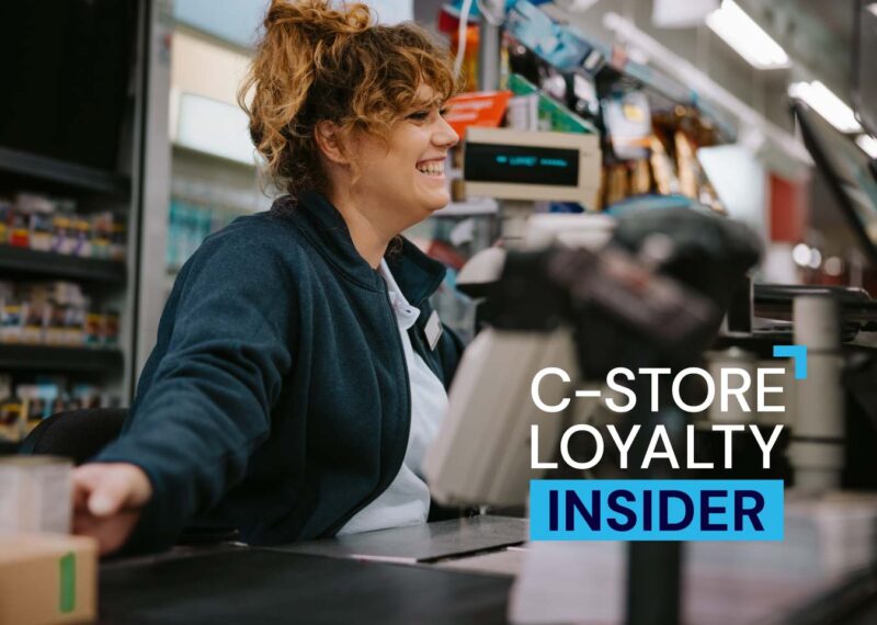 Smiling convenience store cashier helping a customer, representing C-store loyalty and tobacco loyalty engagement strategies.