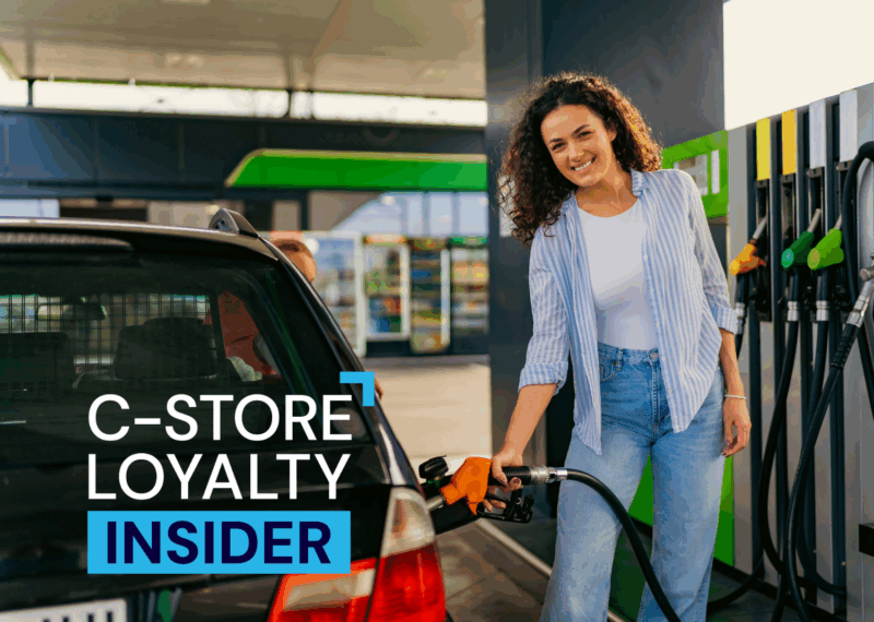 Woman smiling while pumping gas at convenience store