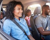 Family driving together on a road trip for Thanksgiving travel.