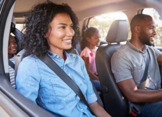 Family driving together on a road trip for Thanksgiving travel.