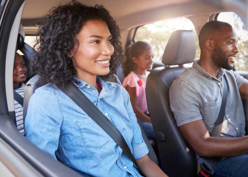 Family driving together on a road trip for Thanksgiving travel.