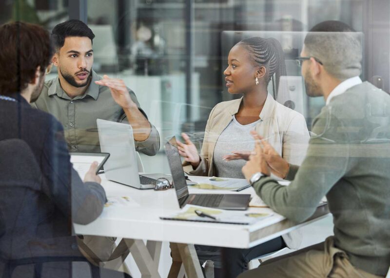 Meeting, collaboration and business people in discussion in the office while working together. Teamwork, planning and group of employees brainstorming with technology for a project in the workplace.