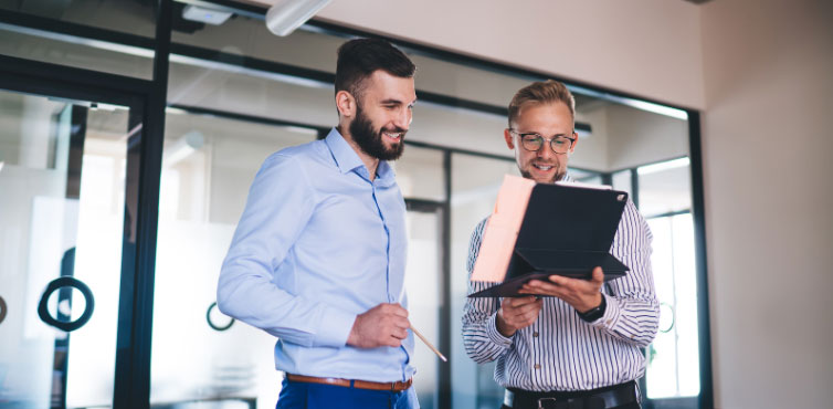 Business managers collaborating on tablet to review compliance and operational workflows