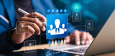 Business professional using a laptop with digital workforce and data integration icons displayed on screen.