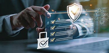 Hand interacting with a digital compliance checklist and security shield interface on a laptop.