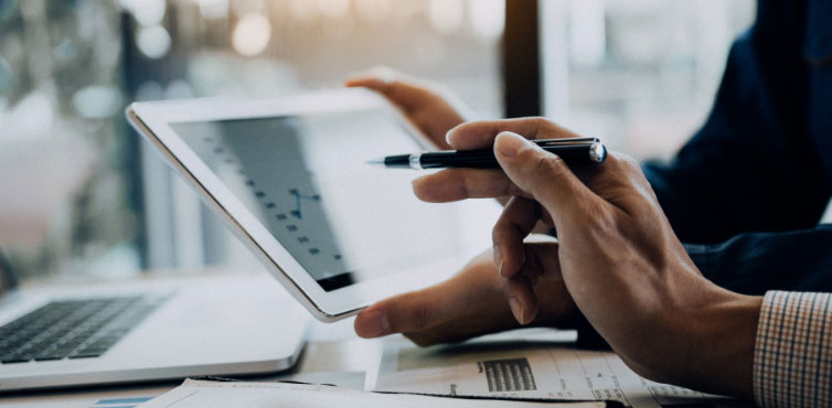 Business professional configuring fleet card controls on tablet with laptop