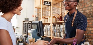 Convenience store clerk assisting a customer at the checkout counter
