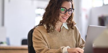 Woman working on a laptop, configuring app content